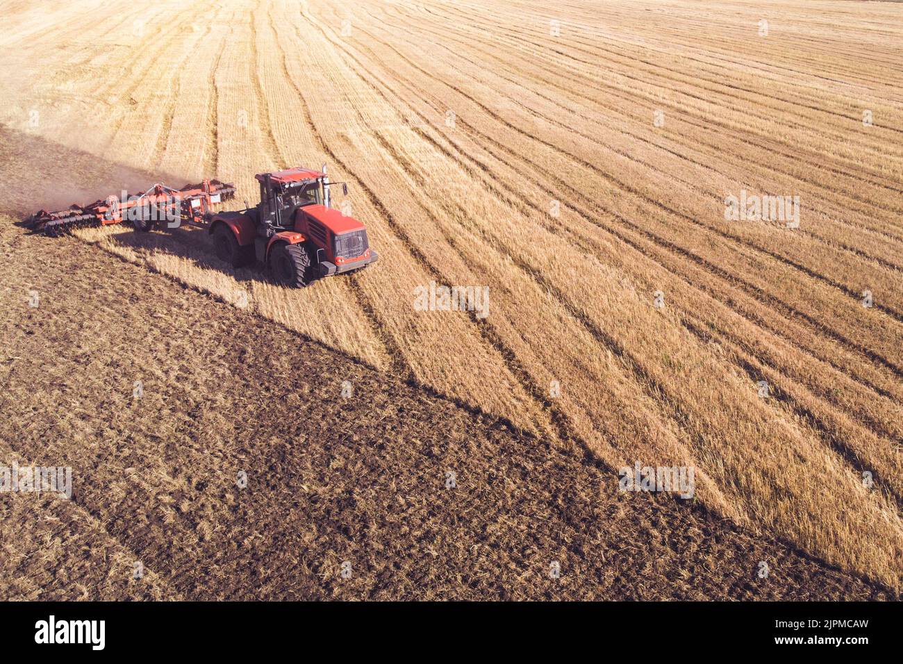 Vue aérienne sur la moissonneuse-batteuse travaille sur le grand champ de blé. La fenaison et de la récolte au début de l'automne sur le terrain. Tracteur tond l'herbe sèche. Preparatio Banque D'Images