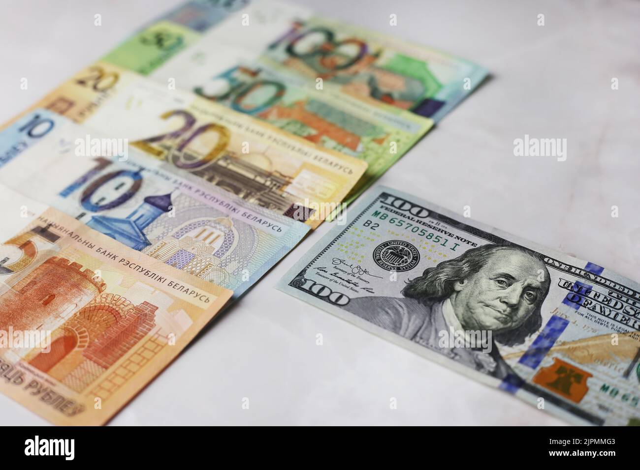 Billets en valeurs unitaires de 100,50,20,10.5 roubles biélorusses et de 100 dollars sur fond gris Banque D'Images