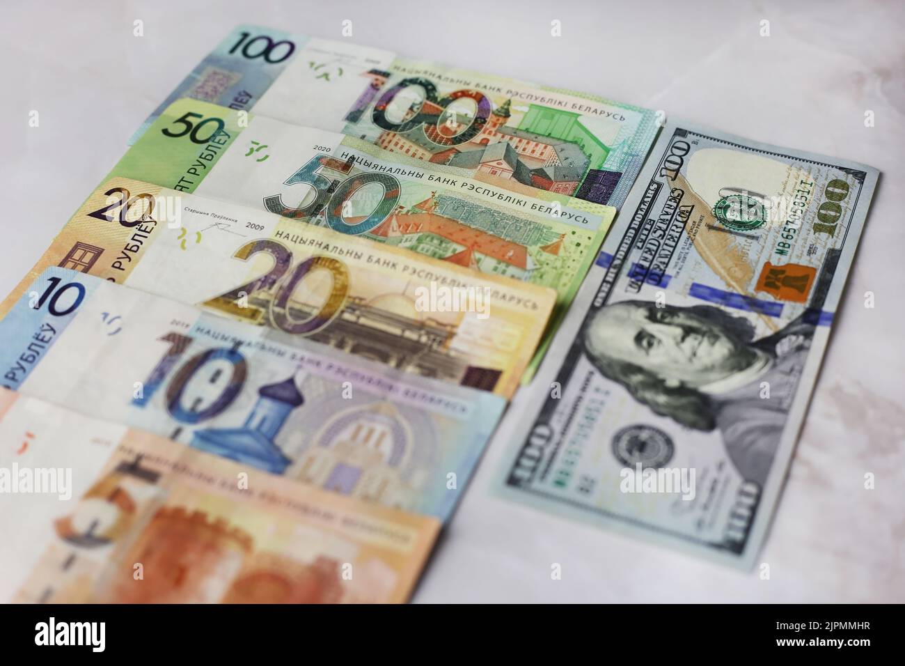 Billets en valeurs unitaires de 100,50,20,10.5 roubles biélorusses et de 100 dollars sur fond gris Banque D'Images