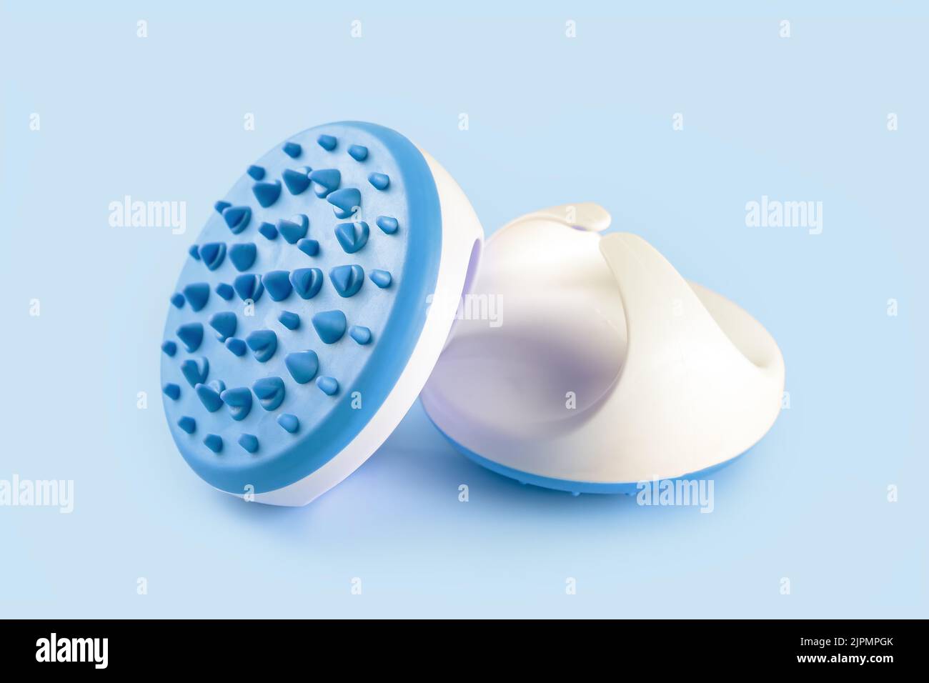 Masseur avec pointes en silicone pour procédure de massage anti-cellulite isolée sur fond bleu. Brosse de massage pour zone corporelle problématique, auto-ca Banque D'Images