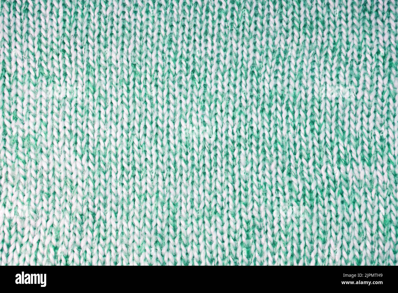 Gros plan en laine tricotée avec motif à pois. Vert brillant couleur laine texture tricots. Jersey tricoté abstrait ajouré. Tissu abstr Banque D'Images