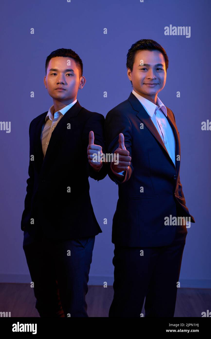 Portrait de deux entrepreneurs heureux montrant le pouce vers le haut Banque D'Images