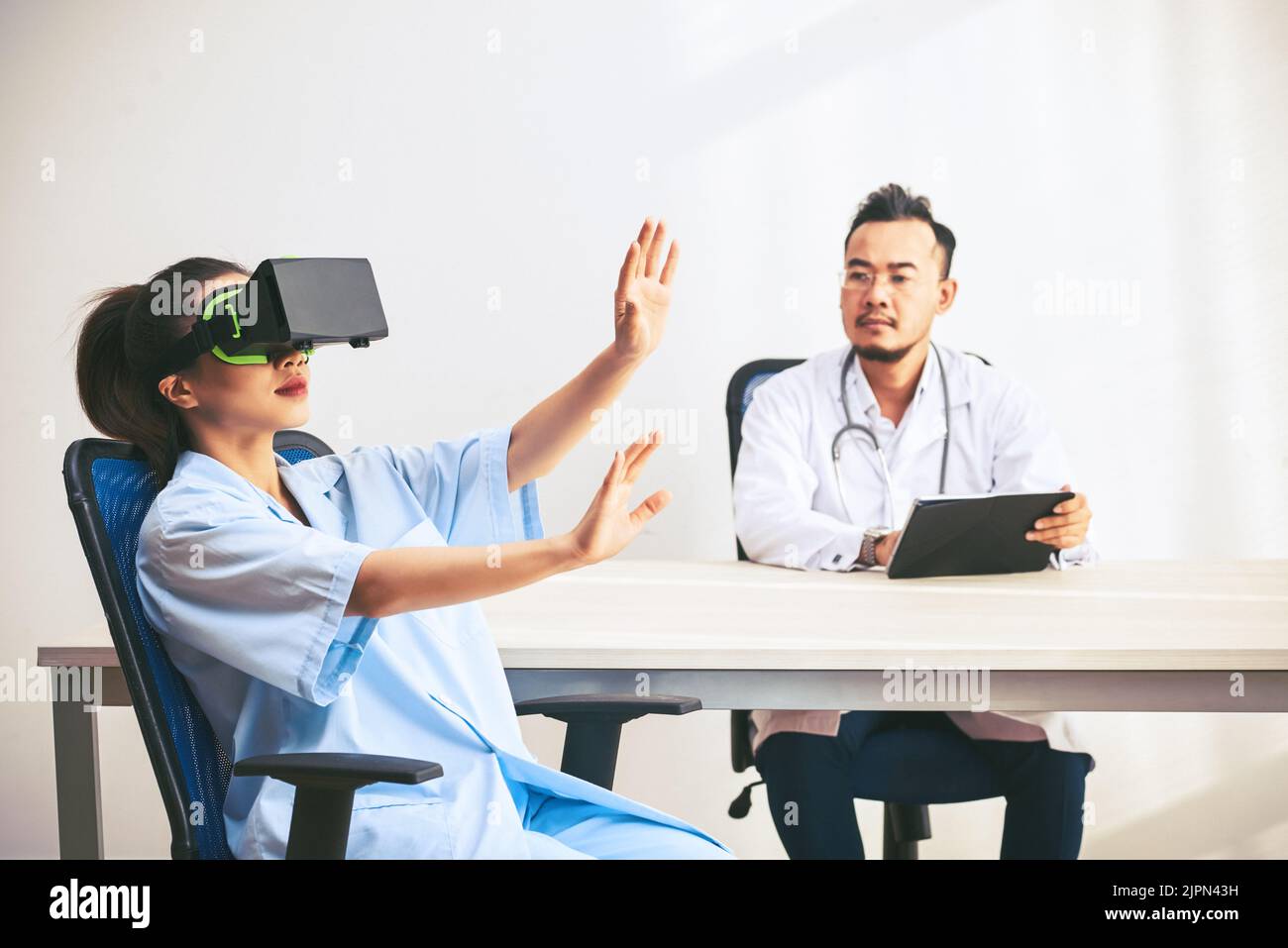 Groupe de professionnels de la santé talentueux qui testent la toute nouvelle application pour micro-casque VR tout en se réunissant au bureau, sur fond blanc Banque D'Images