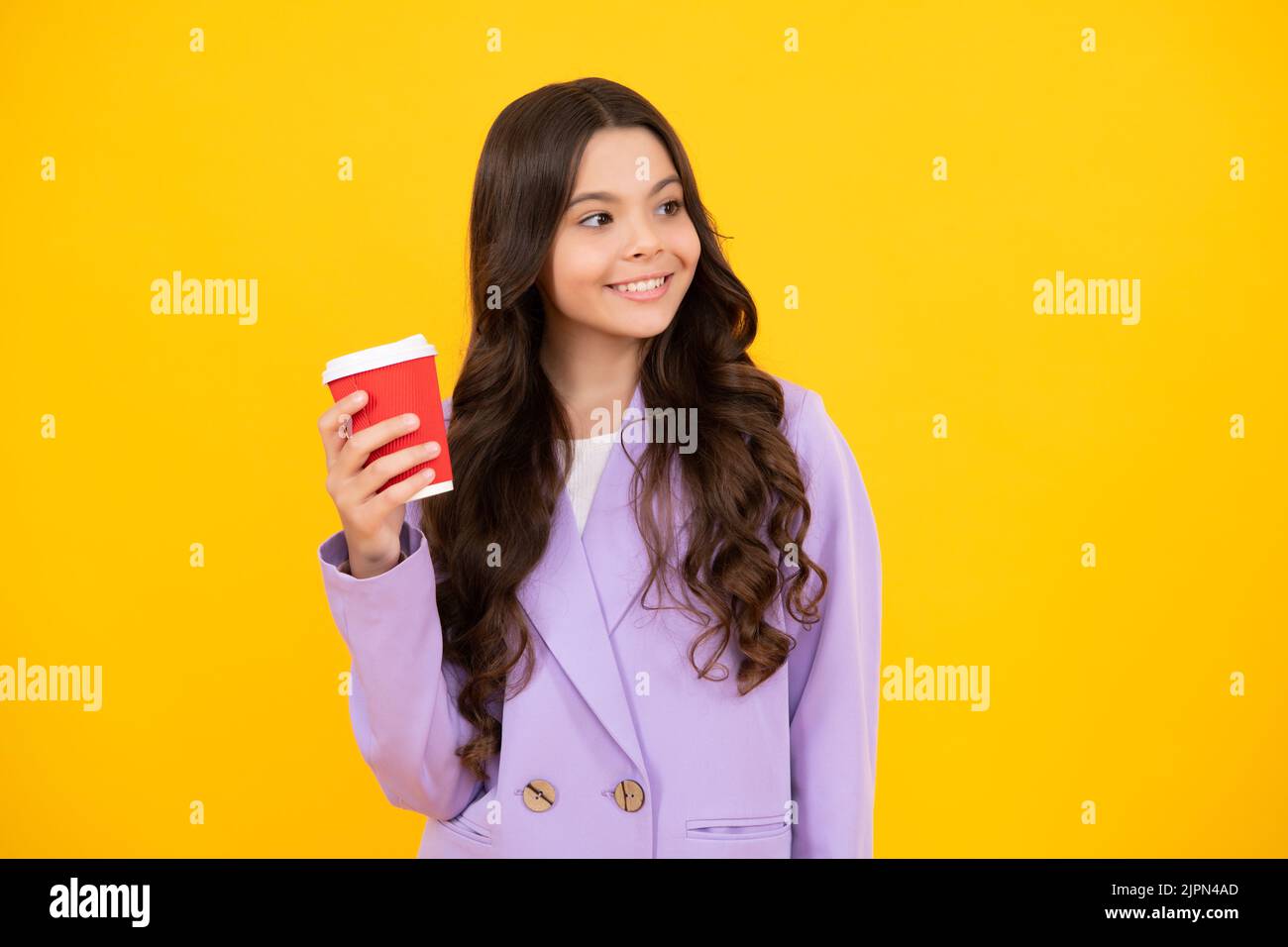 Enfant avec une tasse de café ou de thé isolée sur fond jaune studio. Adolescente avec boisson à emporter. Visage heureux, émotions positives et souriantes de Banque D'Images