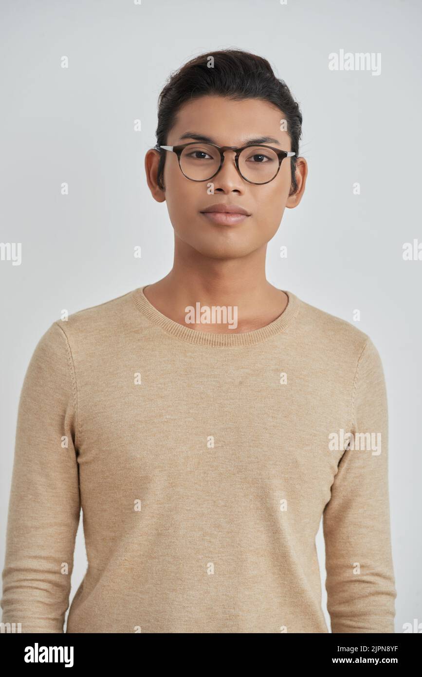 Portrait à la taille du beau asiatique portant des lunettes de vue stylées regardant l'appareil photo tout en se tenant contre un arrière-plan blanc Banque D'Images