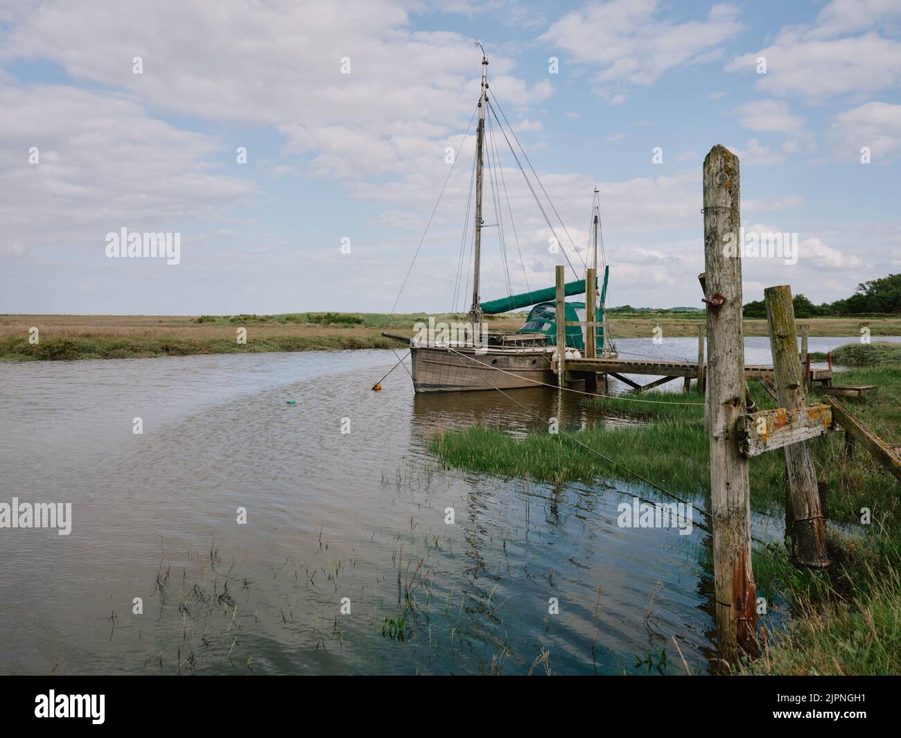 Un yacht amarré dans le paysage marécageux de Thornham Old Harbour sur la côte nord de Norfolk Norfolk Angleterre Royaume-Uni Banque D'Images