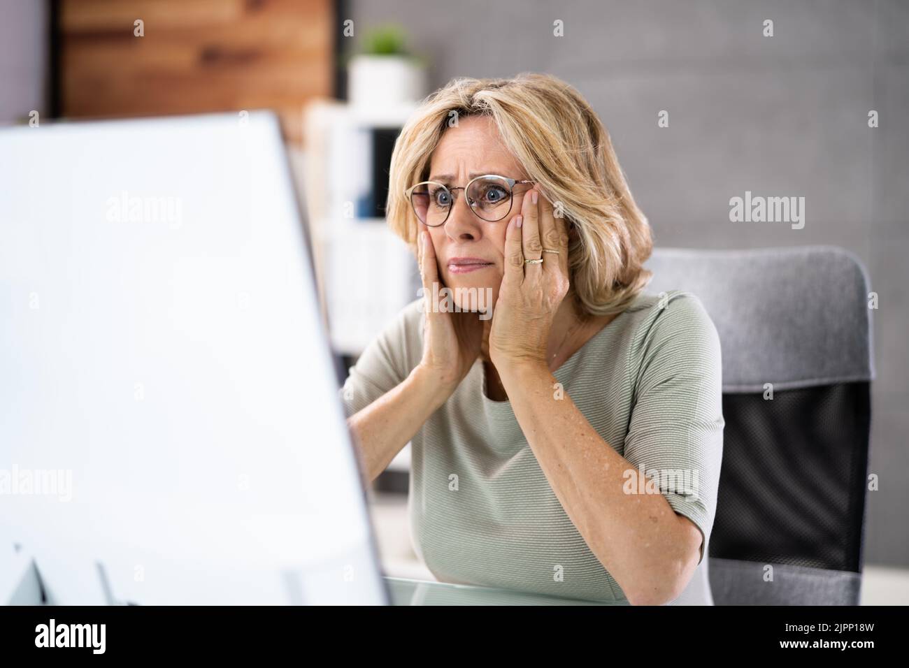 Femme d'affaires frustrée regardant son écran d'ordinateur dans la consternation Banque D'Images