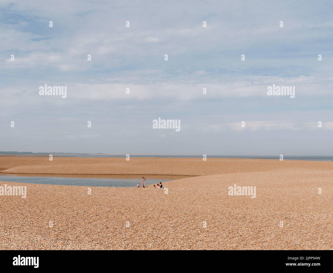 Touristes d'été appréciant la plage de galets à Shingle Street sur la côte de la mer du Nord du comté anglais de Suffolk Angleterre Royaume-Uni Banque D'Images