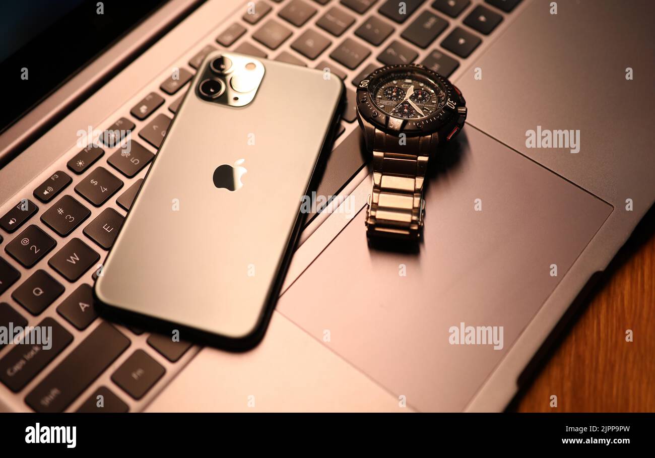 Tbilissi, Géorgie - 26 juillet 2022: Montre moderne de pomme de smartphone sur clavier d'ordinateur portable. Banque D'Images