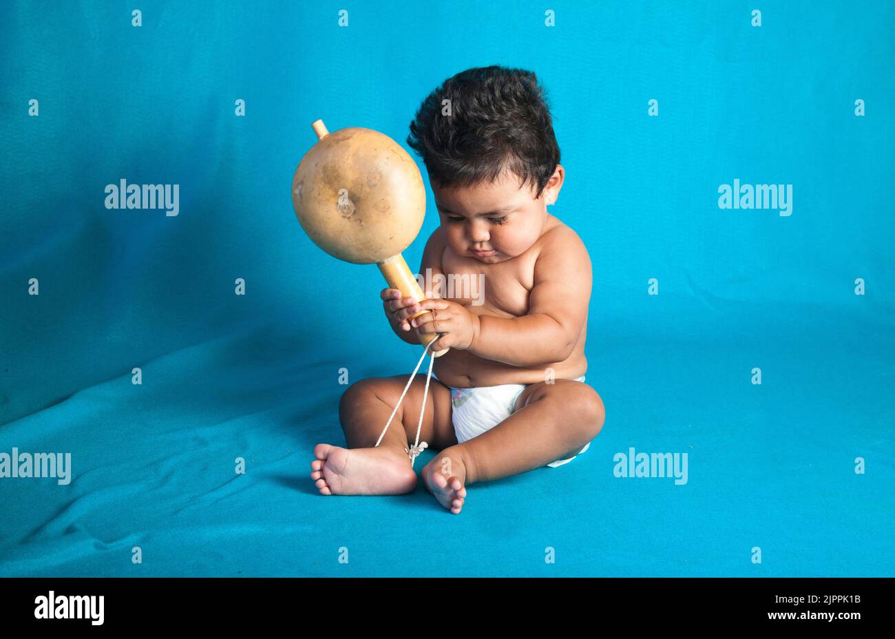 Le bébé américain originaire du Pueblo de Santa Clara secoue un ferraillement traditionnel utilisé pour les danses et les cérémonies au Nouveau-Mexique Banque D'Images