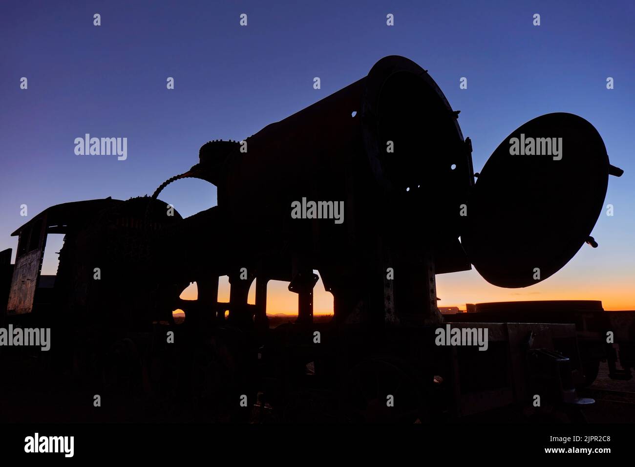 La silhouette d'une vieille locomotive au crépuscule dans le cimetière ferroviaire d'Uyuni, Potosi, Bolivie. Banque D'Images