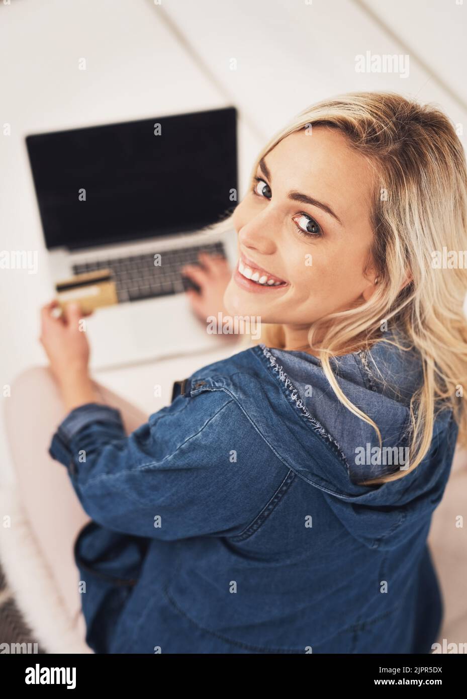 Profitez de vos achats sans tracas depuis votre domicile. Portrait d'une jeune femme effectuant un paiement par carte de crédit sur un ordinateur portable à la maison. Banque D'Images