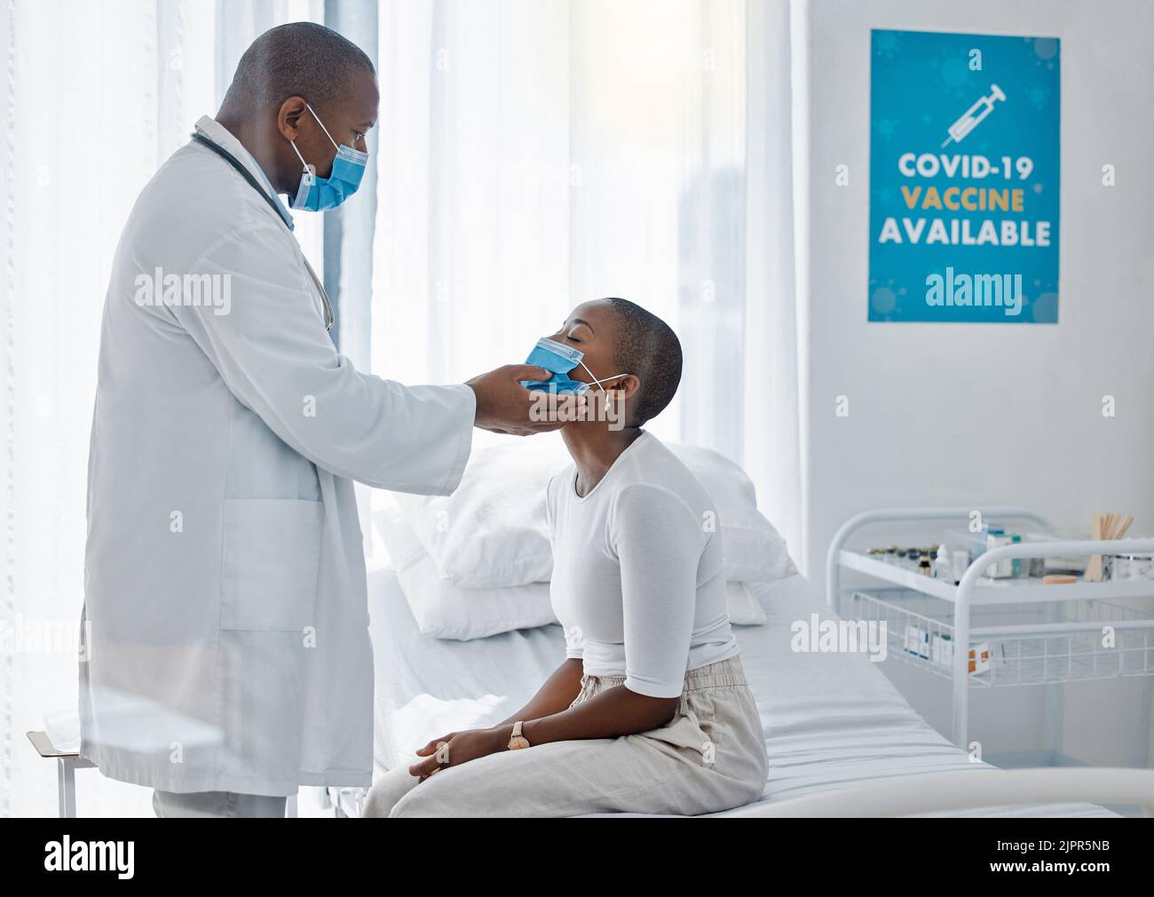 Médecin avec un patient dans un masque covid faisant l'examen de la thyroïde ou de la maladie de gorge pendant un examen médical, visite ou rendez-vous. Assurance Banque D'Images