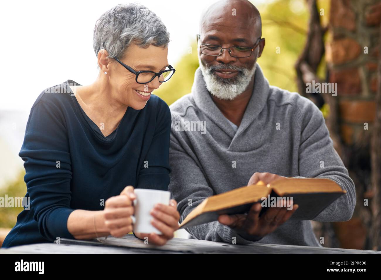 Celui-ci est mon préféré... un couple affectueux de personnes âgées lisant leur bible tout en étant assis dehors. Banque D'Images