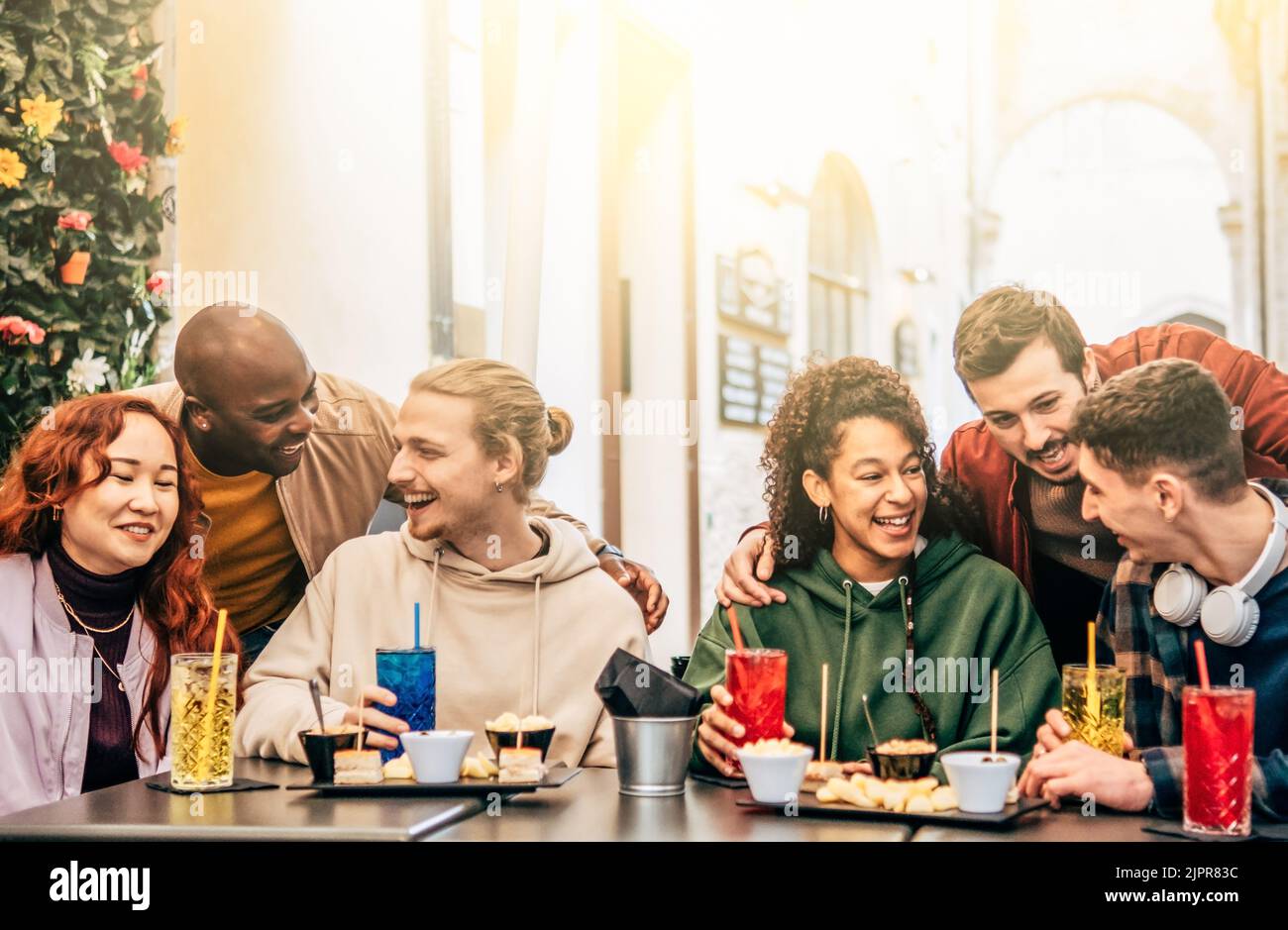 Groupe d'amis boire et manger au café-bar restaurant - les gens parler et s'amuser ensemble à la cafétéria de mode - concept d'amitié avec hap Banque D'Images