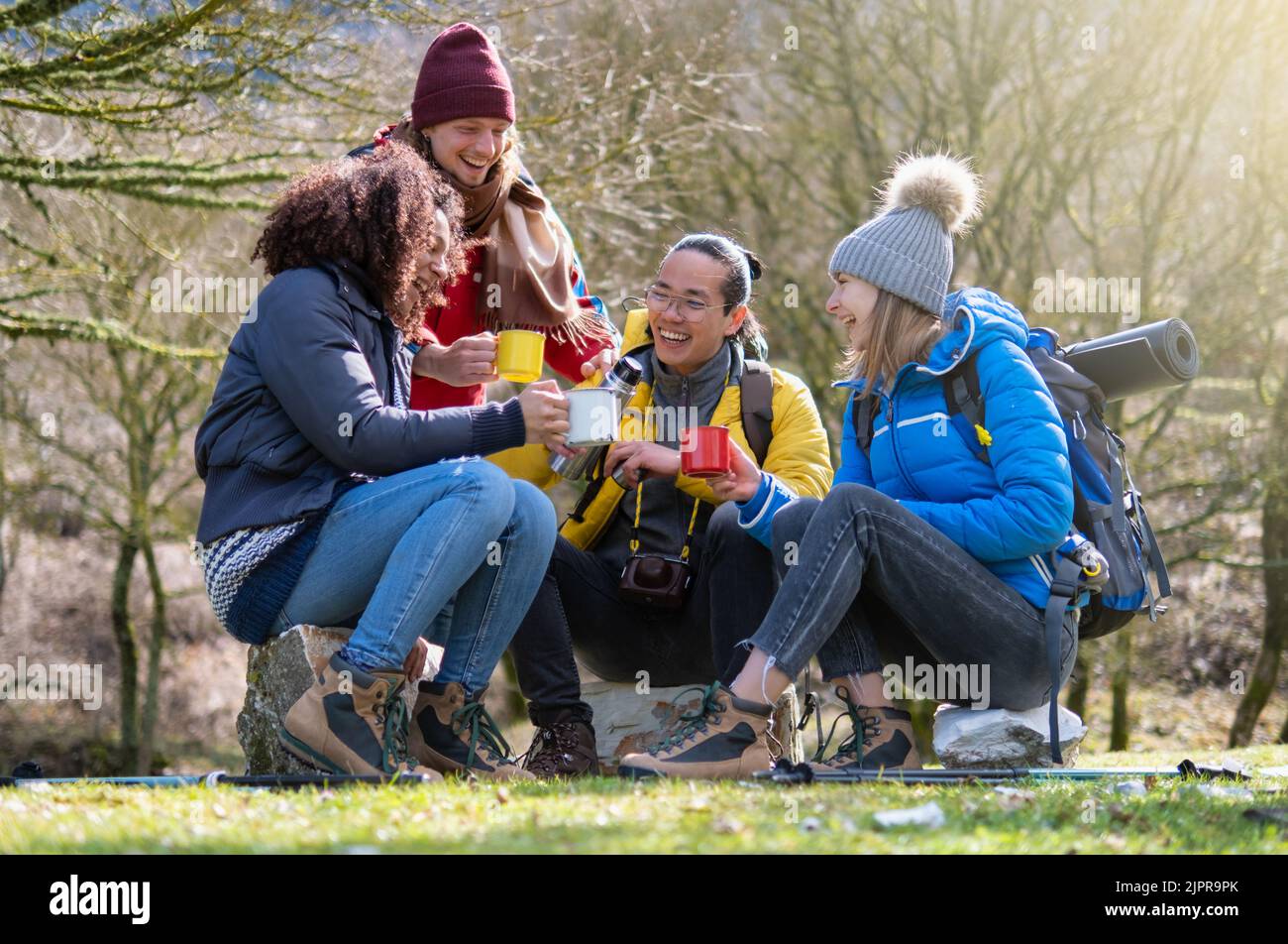 Joyeux groupe de jeunes randonneurs prendre le petit déjeuner sur la montagne - survie et concept d'aventure - foyer sélectif Banque D'Images