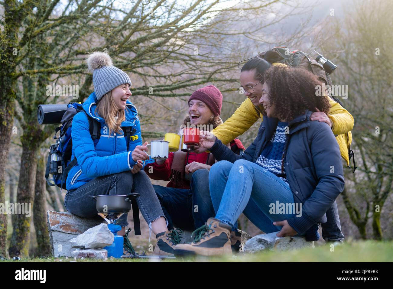 Joyeux groupe de jeunes randonneurs prendre le petit déjeuner sur la montagne - survie et concept d'aventure - foyer sélectif Banque D'Images