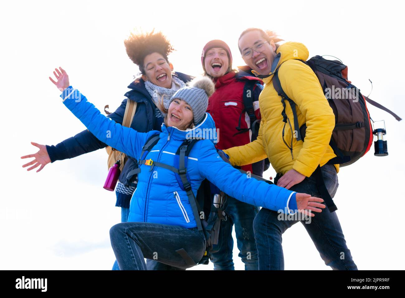 Groupe joyeux d'amis randonneurs prenant un selfie avec des armes dans l'air sur le dessus de la montagne - concept de randonnée ou de trekking - fond blanc Banque D'Images
