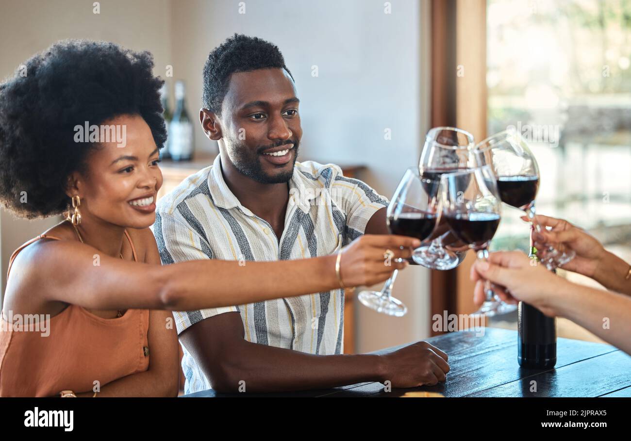 Couple noir célébrant leur anniversaire avec des amis, en dégustant et en buvant du vin rouge. Bonne petite amie et copain lors d'une réunion de famille Banque D'Images