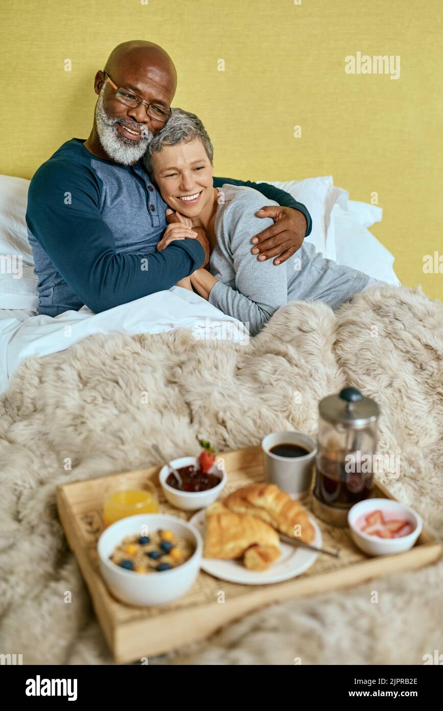 Petit déjeuner au lit. Un couple marié âgé ayant le petit déjeuner au lit à la maison. Banque D'Images
