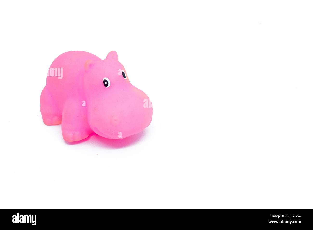 Gros plan d'un jouet hippopotame en plastique de couleur rose isolé sur un fond blanc Banque D'Images