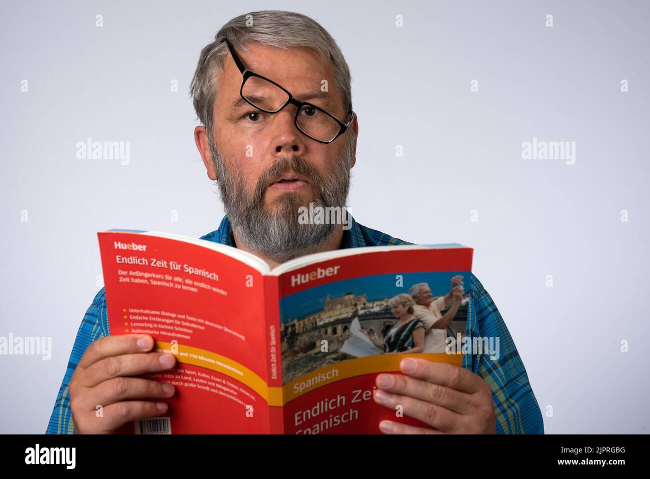 Homme, 55 ans en studio, apprendre une langue, lire dans un livre Banque D'Images