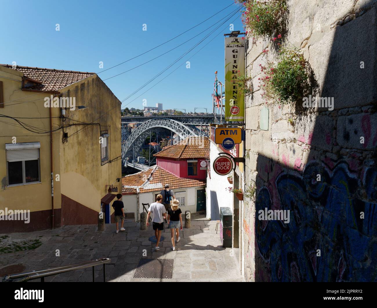 Piétons dans une rue de Porto avec le pont Luis I devant. Portugal Banque D'Images