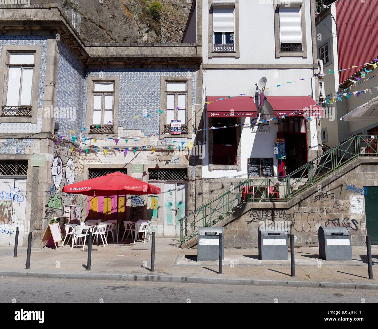 Petit café et restaurants de caractère le long du fleuve à Porto, Portugal. Recouvert de carreaux bleus, une porte rose et jaune et des marches. Banque D'Images