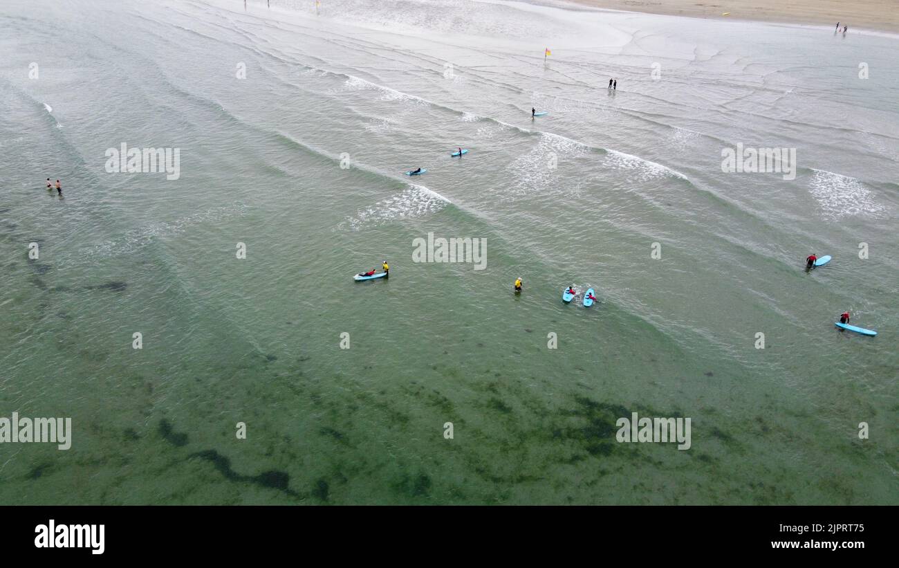 Clonakilty, Irlande, 3 juillet 2022. Les surfeurs novices apprennent à rester sur la planche, vue de dessus. Les gens sont engagés dans les sports nautiques. Vacances en mer. Terre de bord de mer Banque D'Images