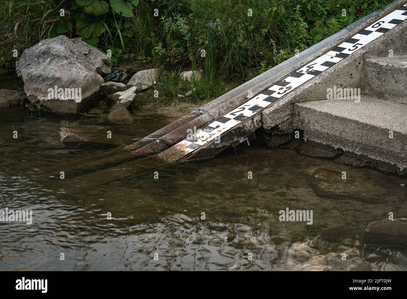 Échelle sur la rive de la rivière pour mesurer le niveau d'eau, qui est très bas sur cette photo Banque D'Images