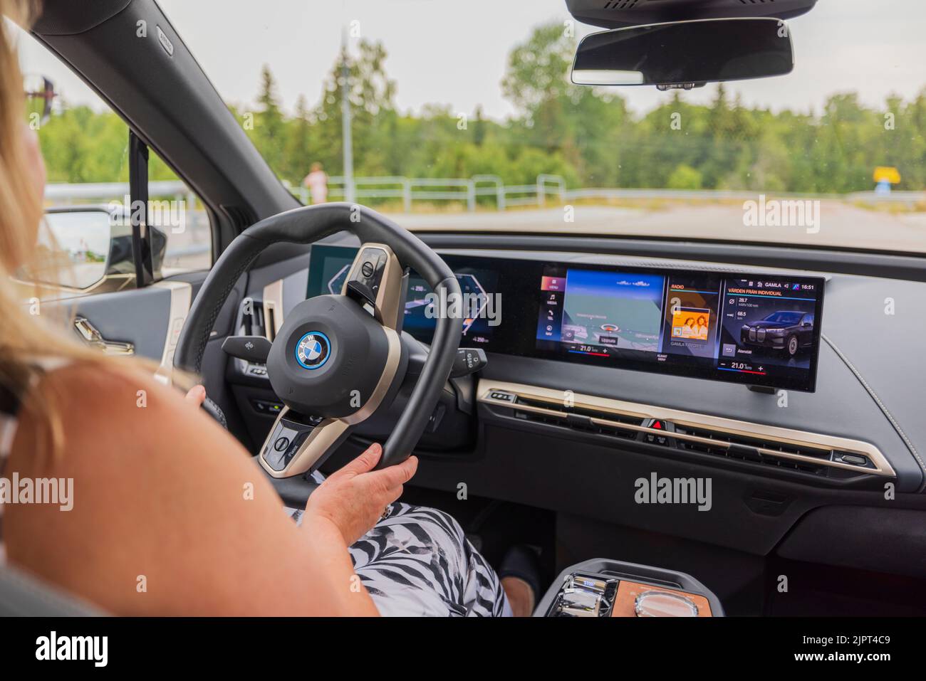 Vue rapprochée de la femme sur le volant de la nouvelle voiture électrique BMW iX40. Suède. Uppsala. Banque D'Images