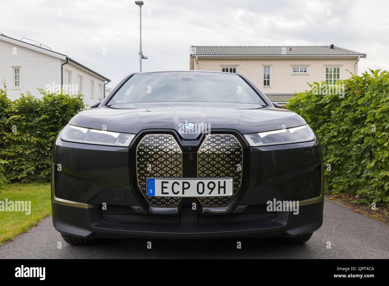 Vue rapprochée de la nouvelle voiture électrique BMW IX40 dans le parking privé de la villa, le jour d'été nuageux. Suède. Banque D'Images