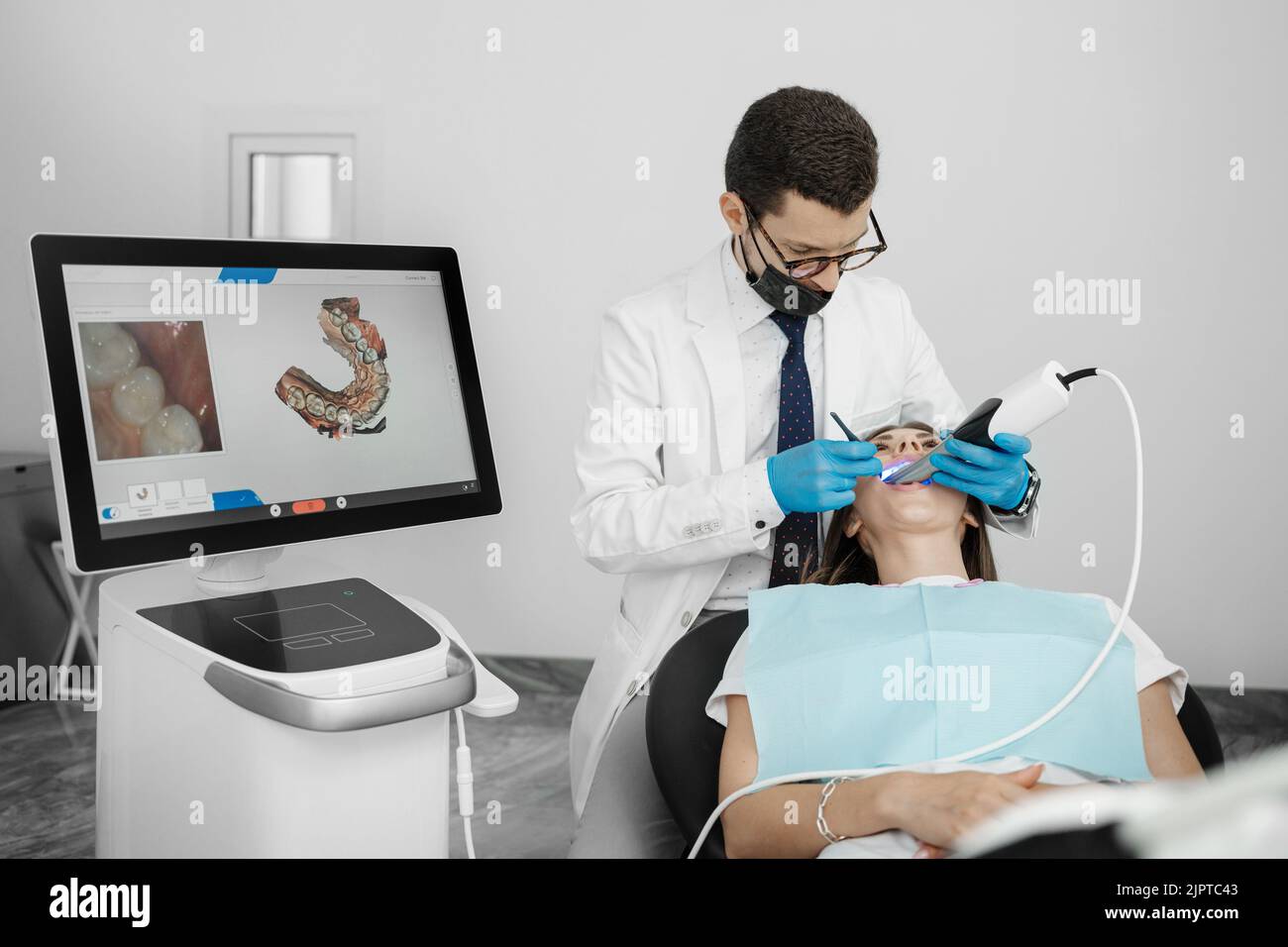 Patient en orthodontie masculin avec scanner intra-buccal et commandes à l'écran. Prosthodontie et stomatologie concept. Banque D'Images