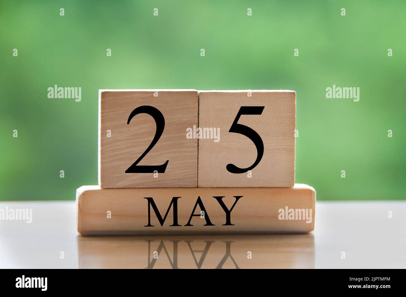 Texte de la date du calendrier 25 mai sur des blocs de bois avec un arrière-plan de nature flou. Concept d'espace de copie et de calendrier. Banque D'Images