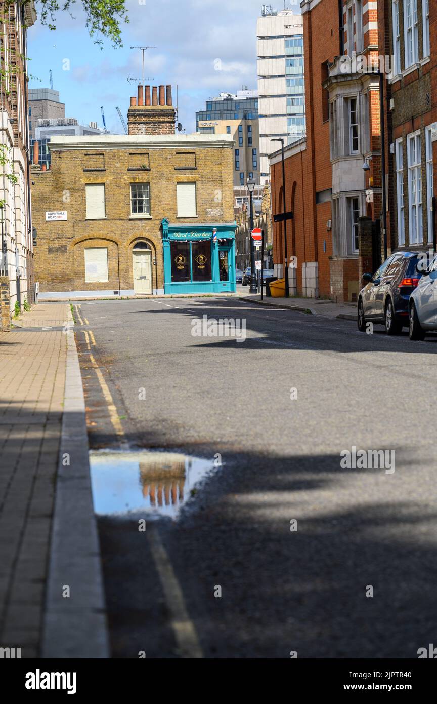 LONDRES - 20 mai 2022: Vieilles cheminées sur bâtiment en brique et se reflète dans la flaque sur la route Banque D'Images