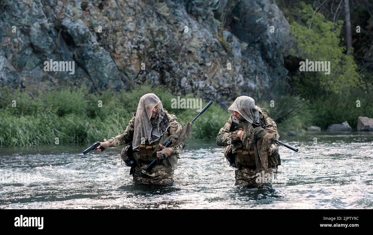 Deux soldats mercenaires ford une rivière lors d'une opération de sabotage. Le concept des missions modernes de sabotage et des provocations derrière les lignes ennemies. COLLAGE Banque D'Images