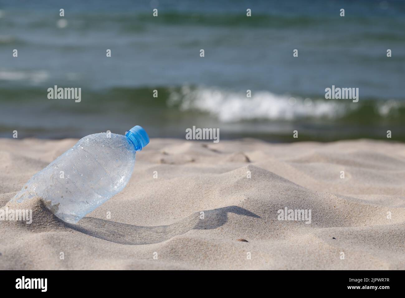 Bouteille de boisson en plastique lavée à la plage. Gros plan, mise au point sélective, PET transparent. Banque D'Images