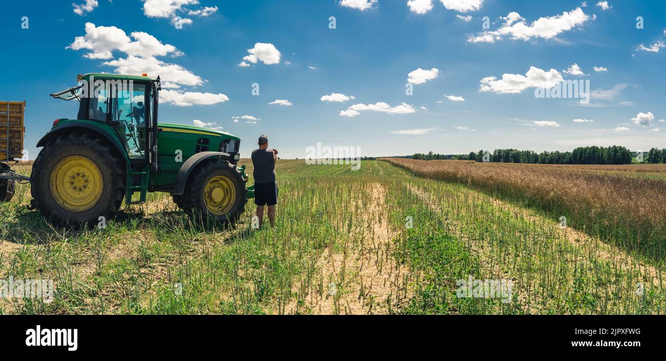 un agriculteur travaillant dans le champ avec son tracteur, bonne récolte. Photo de haute qualité Banque D'Images