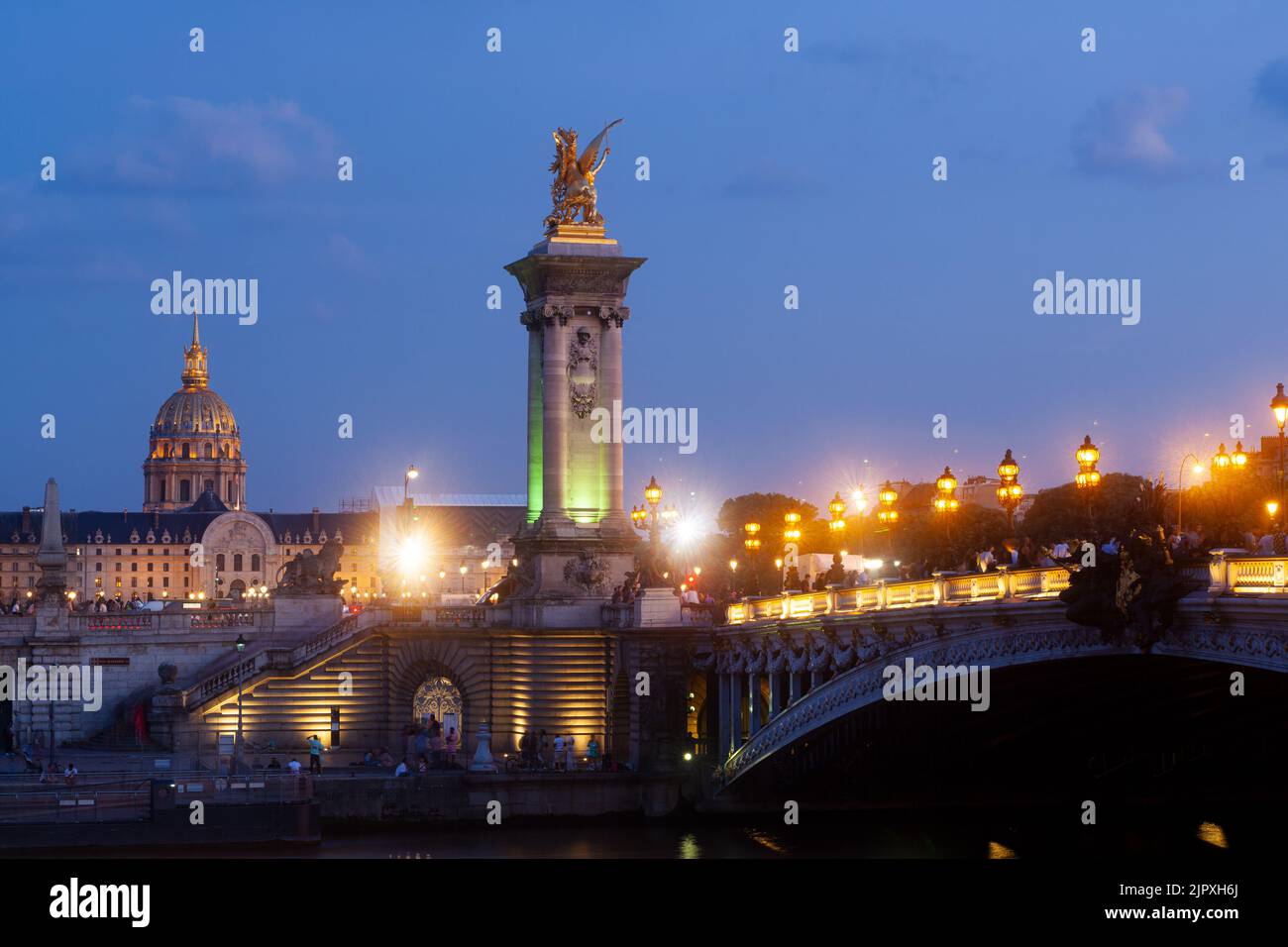 Pont Alexandre III Pont et lampadaires illuminés au coucher du soleil avec vue sur les Invalides. 7ème arrondissement, Paris, France Banque D'Images