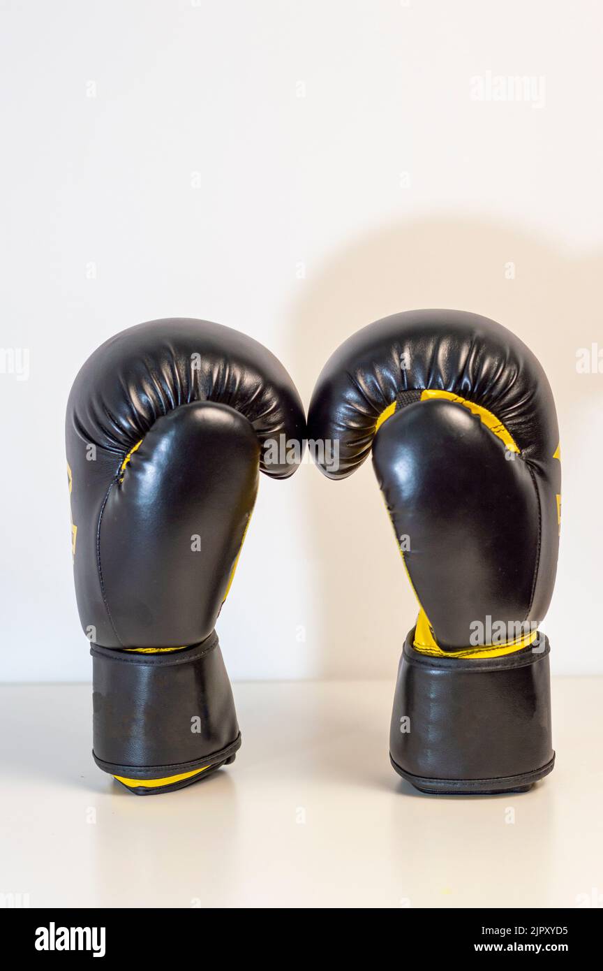 Gros plan des gants de boxe noirs sur fond blanc. Paire de gants de boxe noirs isolés sur fond blanc Banque D'Images