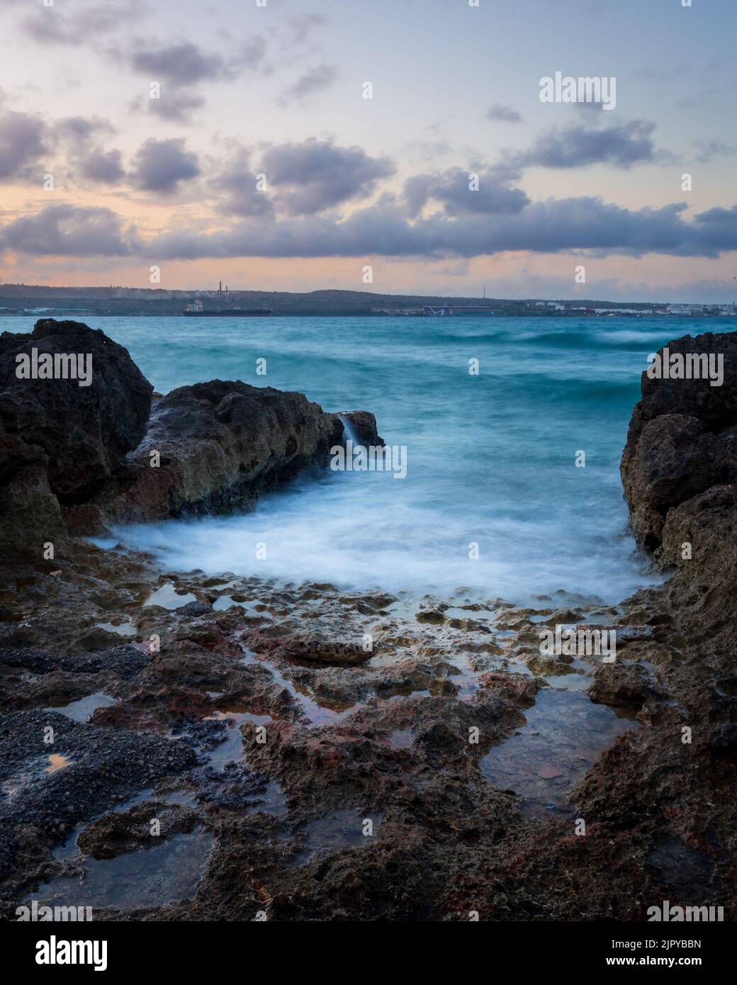 Coucher de soleil dans la baie de Matanzas en été avec le soleil se reflète dans l'eau et les rochers au premier plan. Banque D'Images