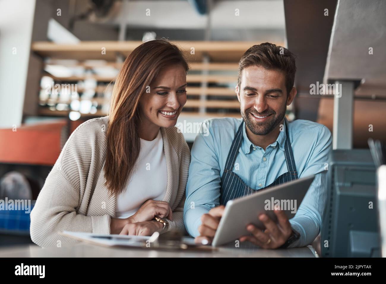IVE a numérisé tous nos stocks pour en faciliter la surveillance. Deux propriétaires d'entreprise travaillent ensemble dans un café. Banque D'Images