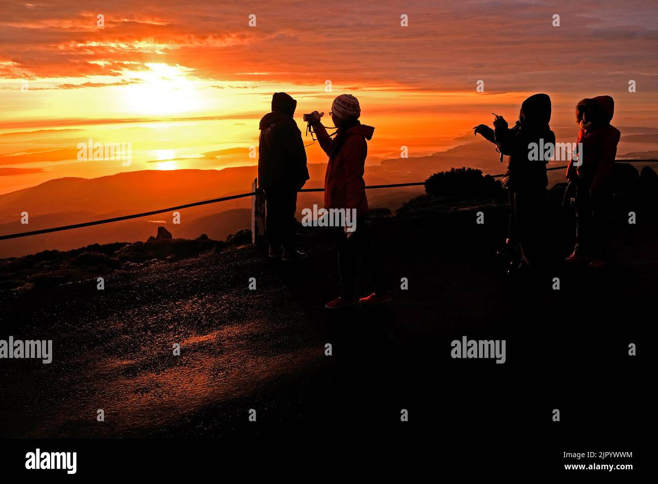 Touristes regardant le lever du soleil depuis le sommet de kunanyi/Mt Wellington à Hobart, Tasmanie (altitude 1271 mètres au-dessus du niveau de la mer) Banque D'Images