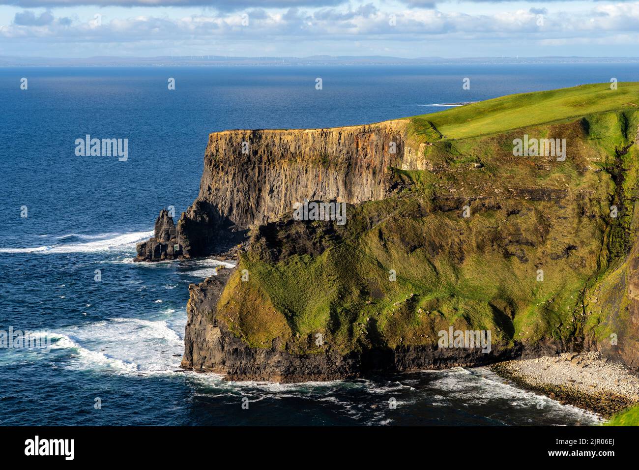 Cette superbe photo capture la beauté des falaises majestueuses, avec la mer bleu profond sous elles, le ciel bleu clair au-dessus. Banque D'Images