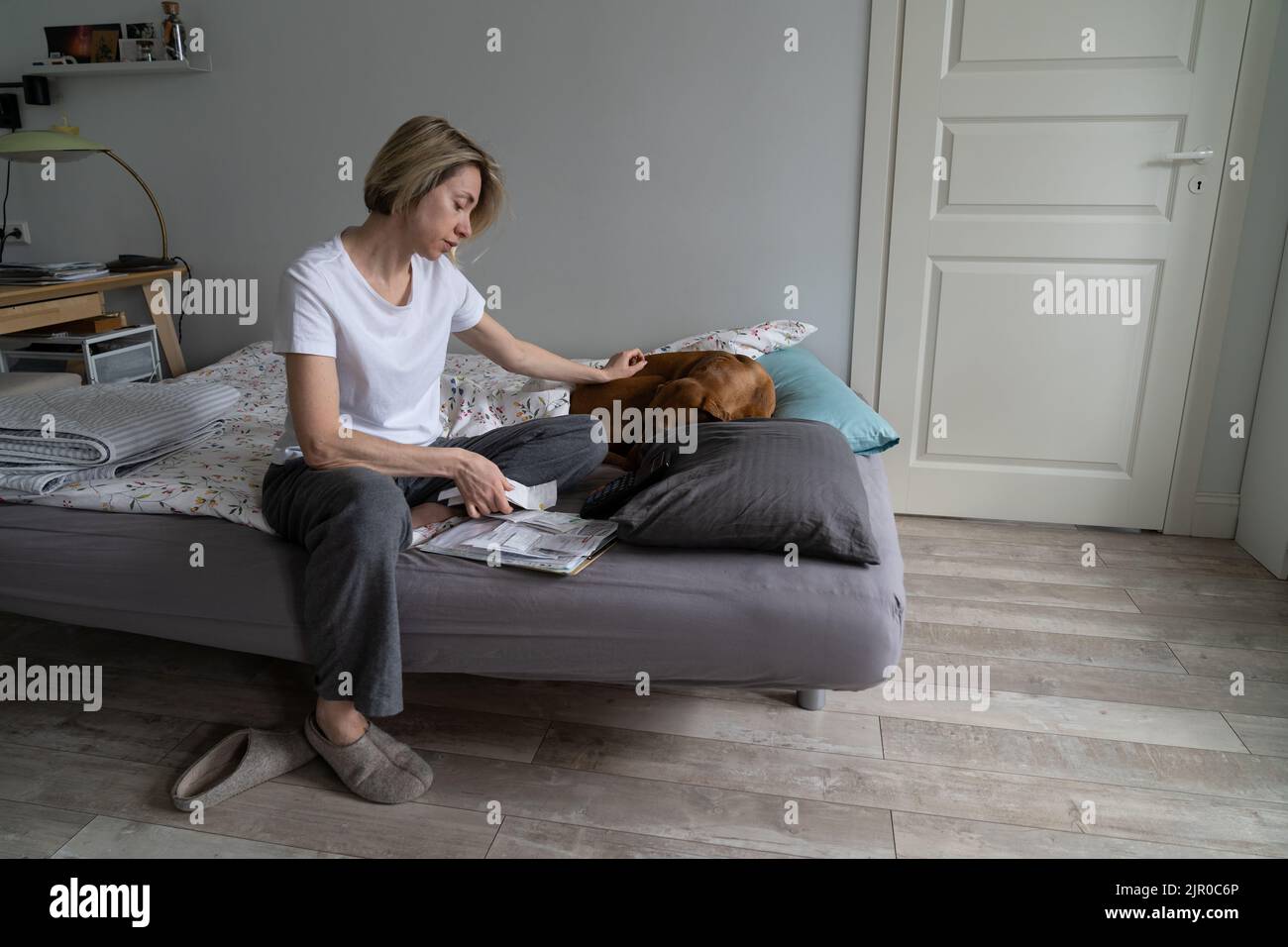 Une femme d'âge moyen semble déçue par les grosses factures et les coups de chien seulement vrai ami Banque D'Images