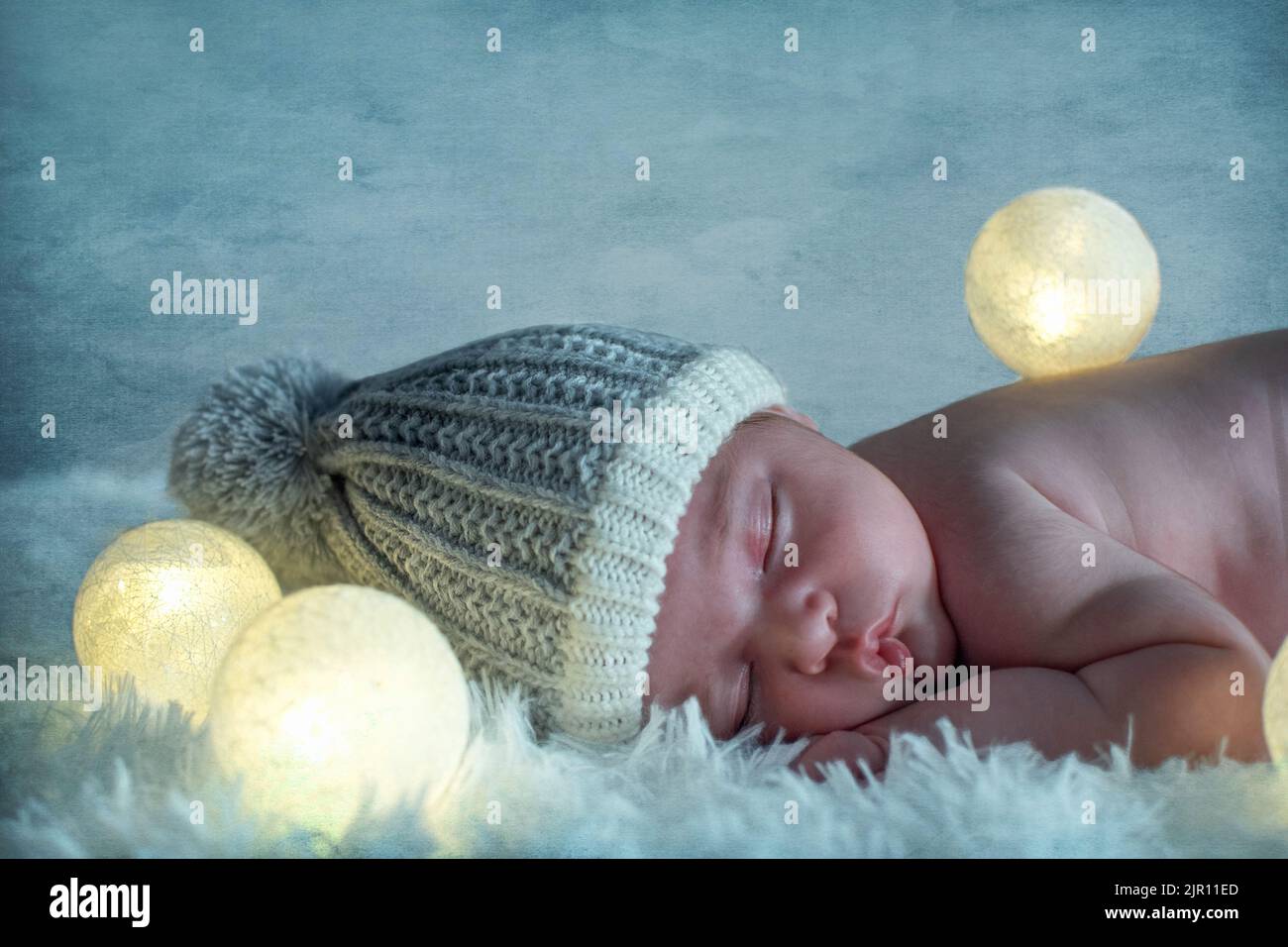 Nouveau-né dormant dans un tapis avec veilleuse, fond bleu. dix jours. Images mignonnes de bébé dormant sur le sol confortable avec éclairage en étain Banque D'Images