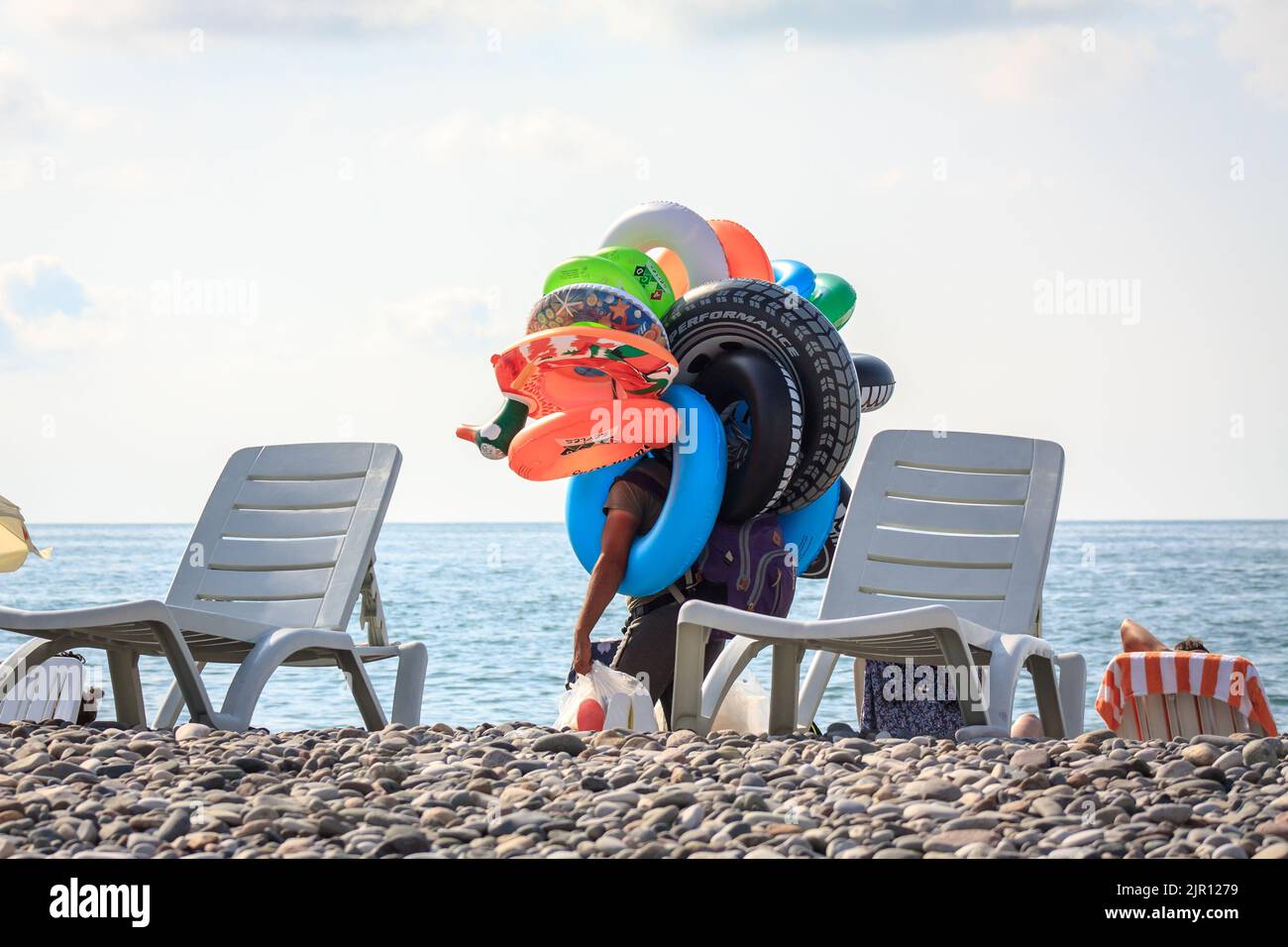 Un homme vend des jouets gonflables sur une plage. Vendeur de plage. Batumi, Géorgie - 2 juillet 2021 Banque D'Images