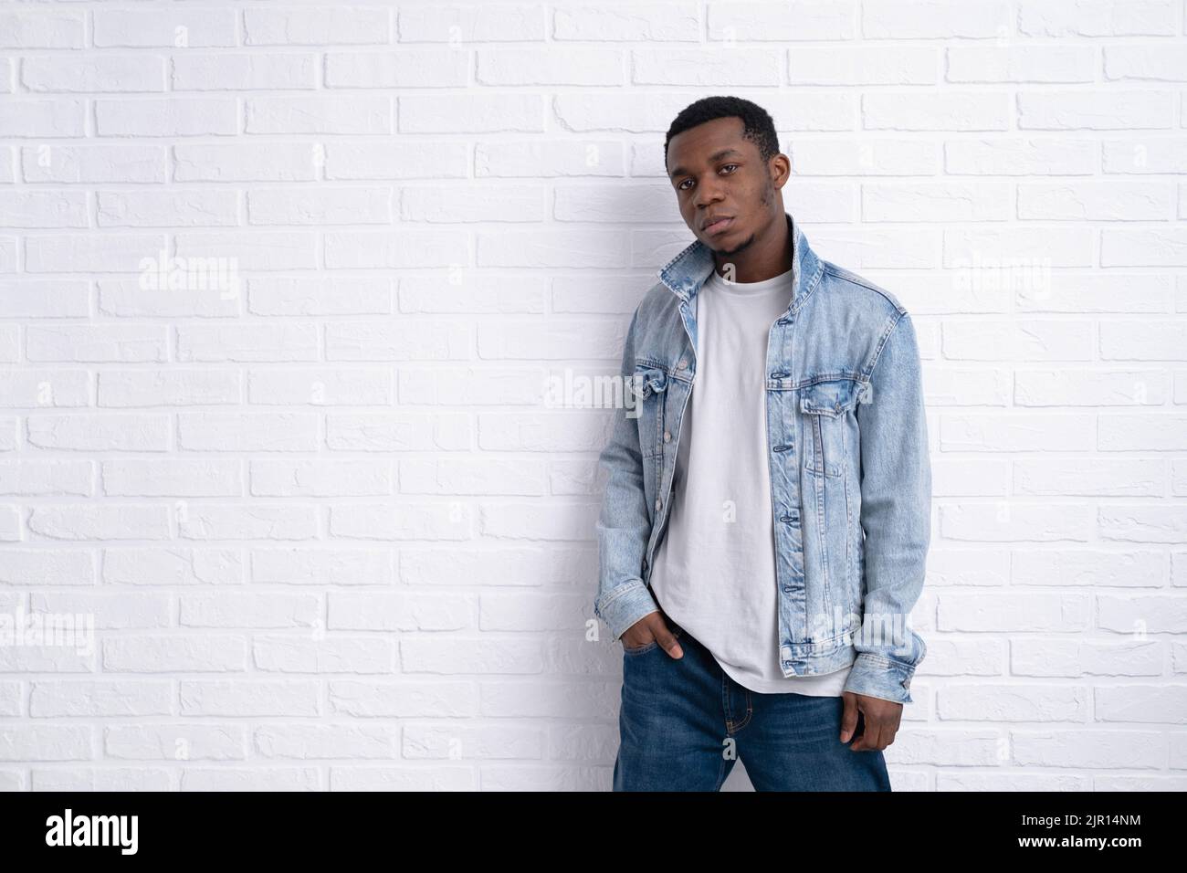 Portrait jeune beau africain noir homme portant Jean veste denim contre la brique avec mur extérieur avec copyspace. Banque D'Images
