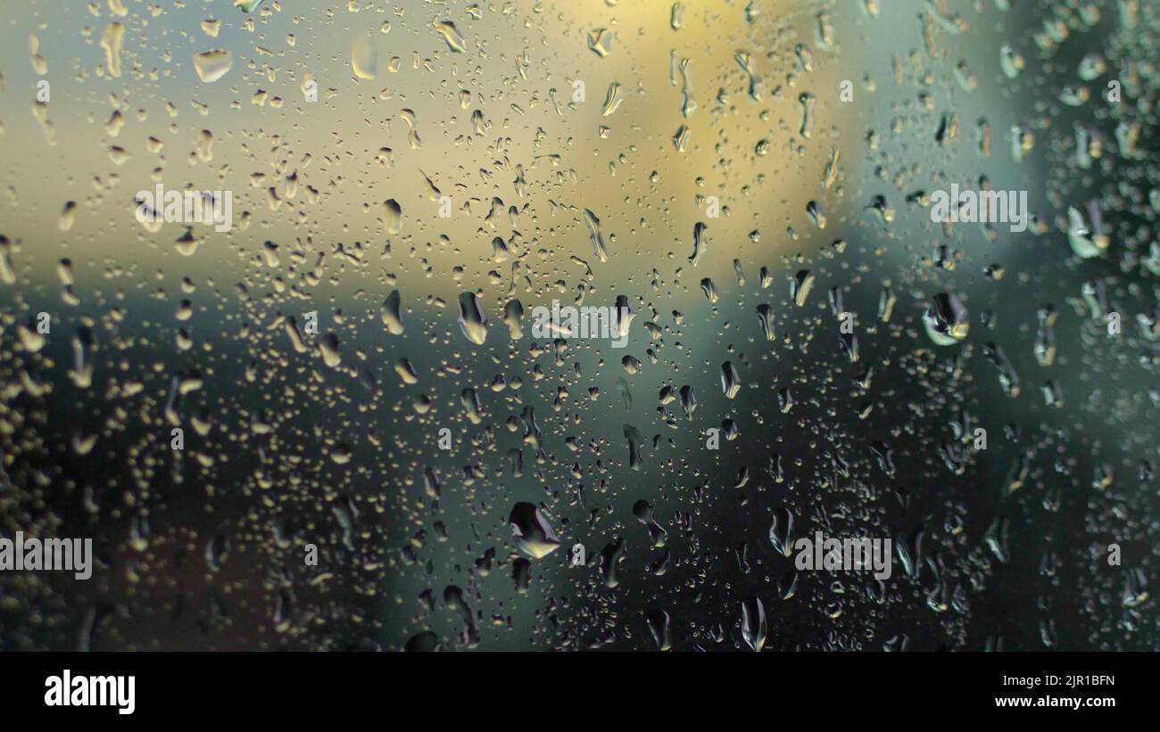 gros plan, sur le verre il y a de grandes gouttes de pluie, d'eau, de gouttes d'eau sur une structure de verre, surface. verre coloré, fond. Photo de haute qualité Banque D'Images