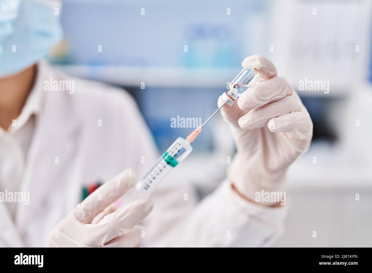 Jeune scientifique tenant un vaccin covid en laboratoire Banque D'Images